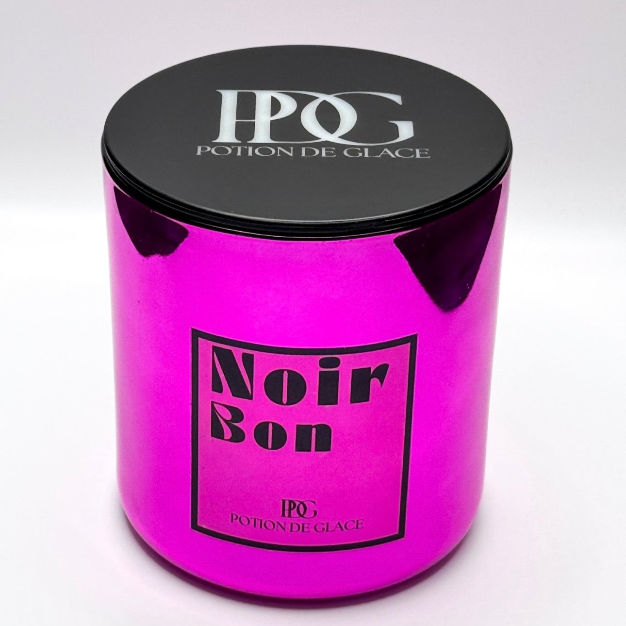 Noir Bon candle by Potion de Glace, with a mirrored pink container, made from natural soy wax and infused with a cherry fragrance. A luxurious piece to create a warm and fragrant ambiance in any space.